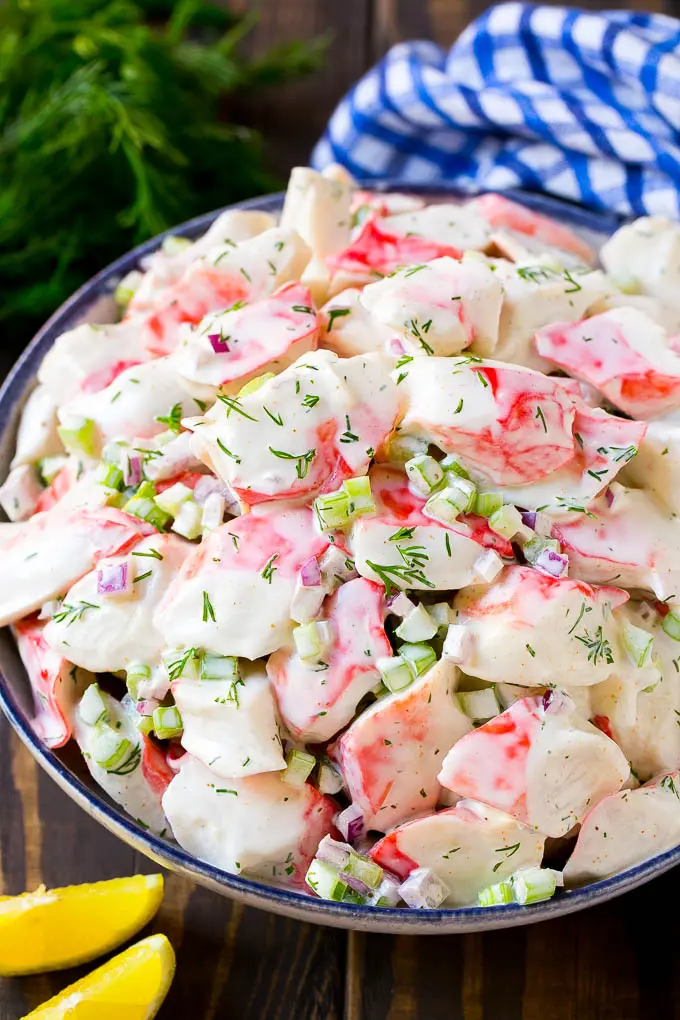 Creamy crab salad with fresh vegetables and dill in a ...